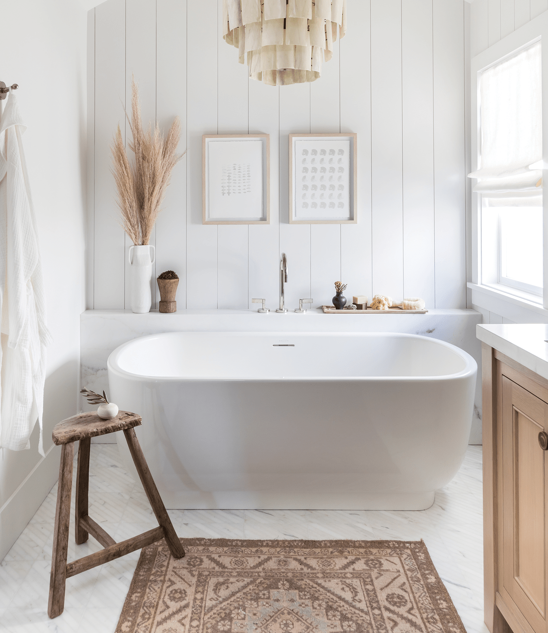 In the primary bathroom, soft-pink hues and light marble create a delicate aesthetic.